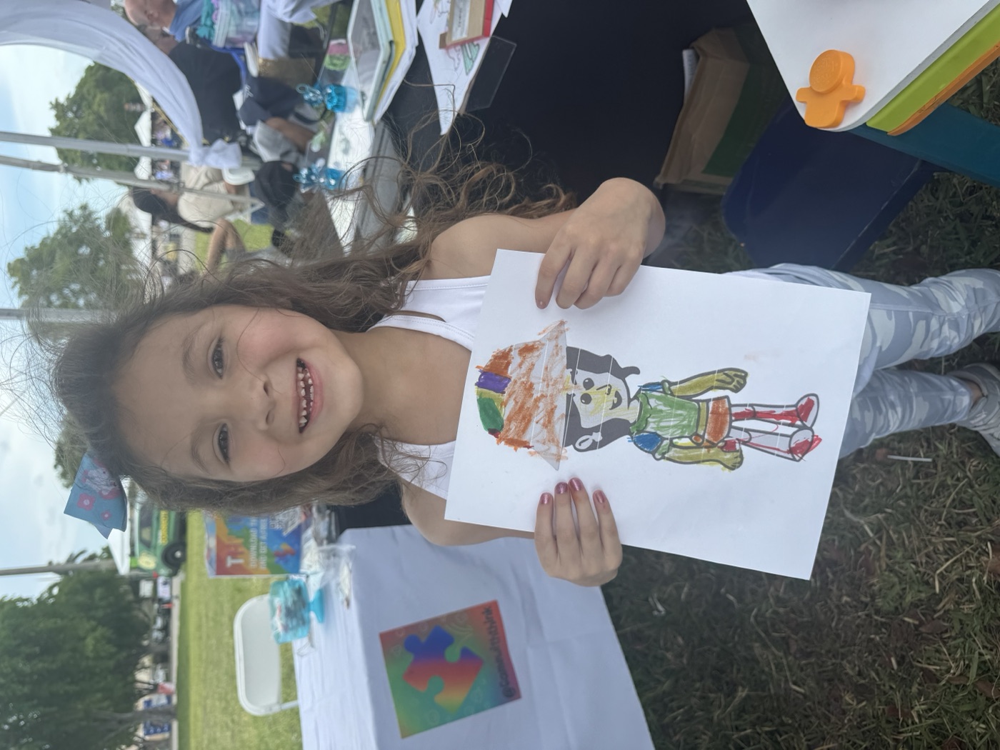 Child holding colorful character artwork